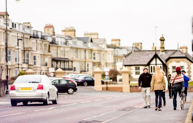 An image of a street with pedestrians and cars