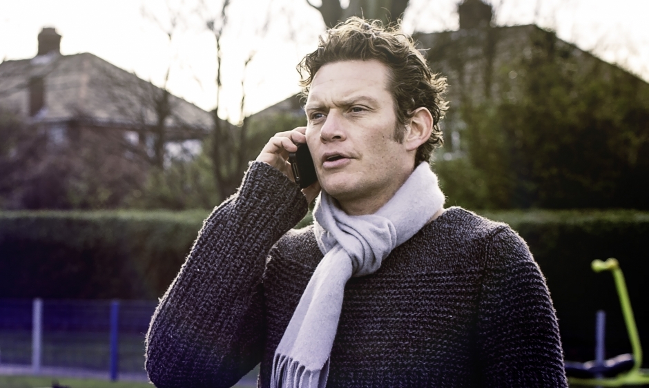 An image of a man talking on the phone in a park