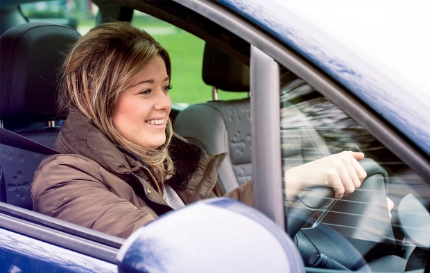 An image of a young woman driving a car