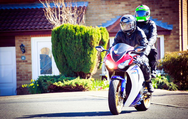 An image of a motorcyclists and a pillion passenger on a motorbike