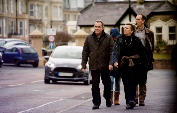 An image of a group of pedestrians walking beside a road