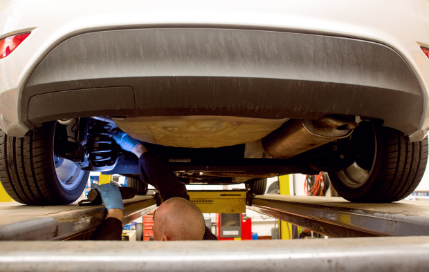 An image of a mechanic undeneath a car