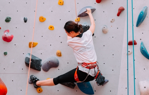 A person scaling a climbing wall