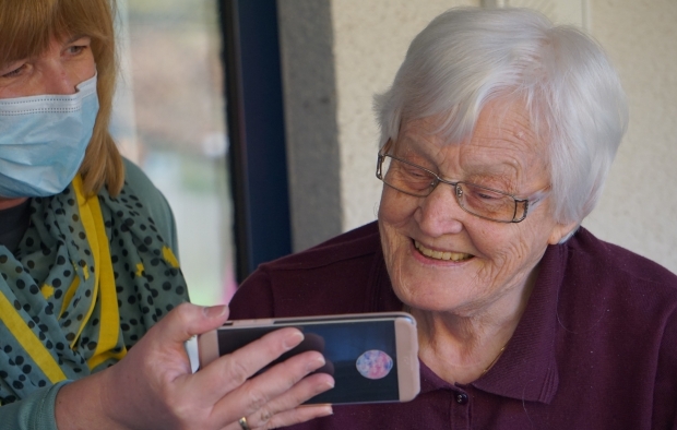 An elderley lady looking at a phone