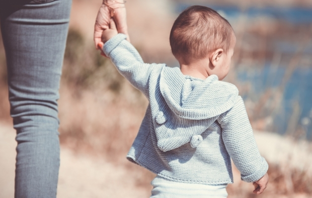 A child walking with an adult holding their hand