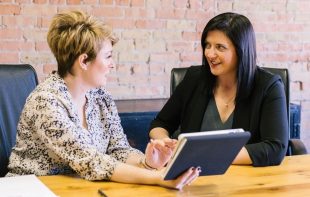 An image of two women having a meeting and holding a tablet