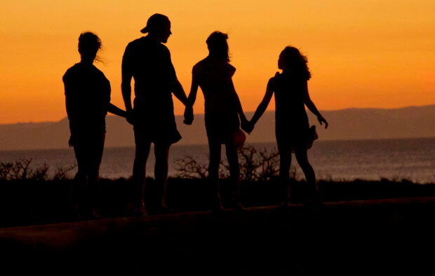A family staring into the sunset