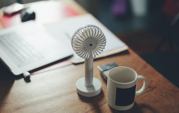 A desk fan helps regulate temperature in the office