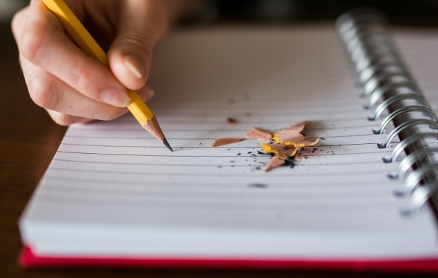 A student writing on a sheet of paper at school