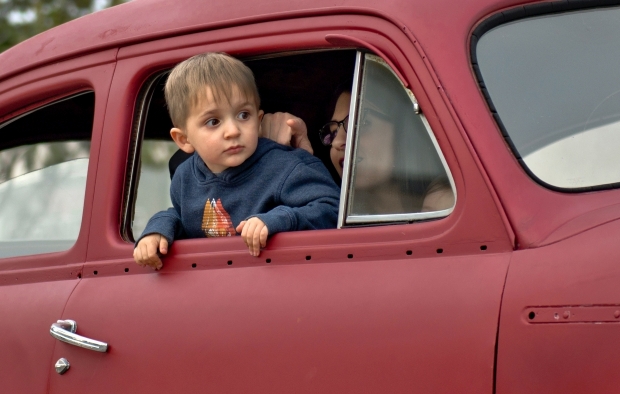 A child puts his head out of a car window