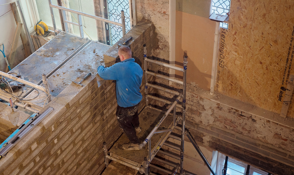 An image of a builder working at height on scaffolding